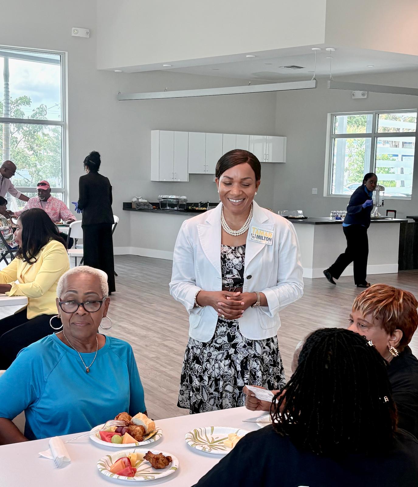 Tamar Hamilton speaking with residents at a community lunch